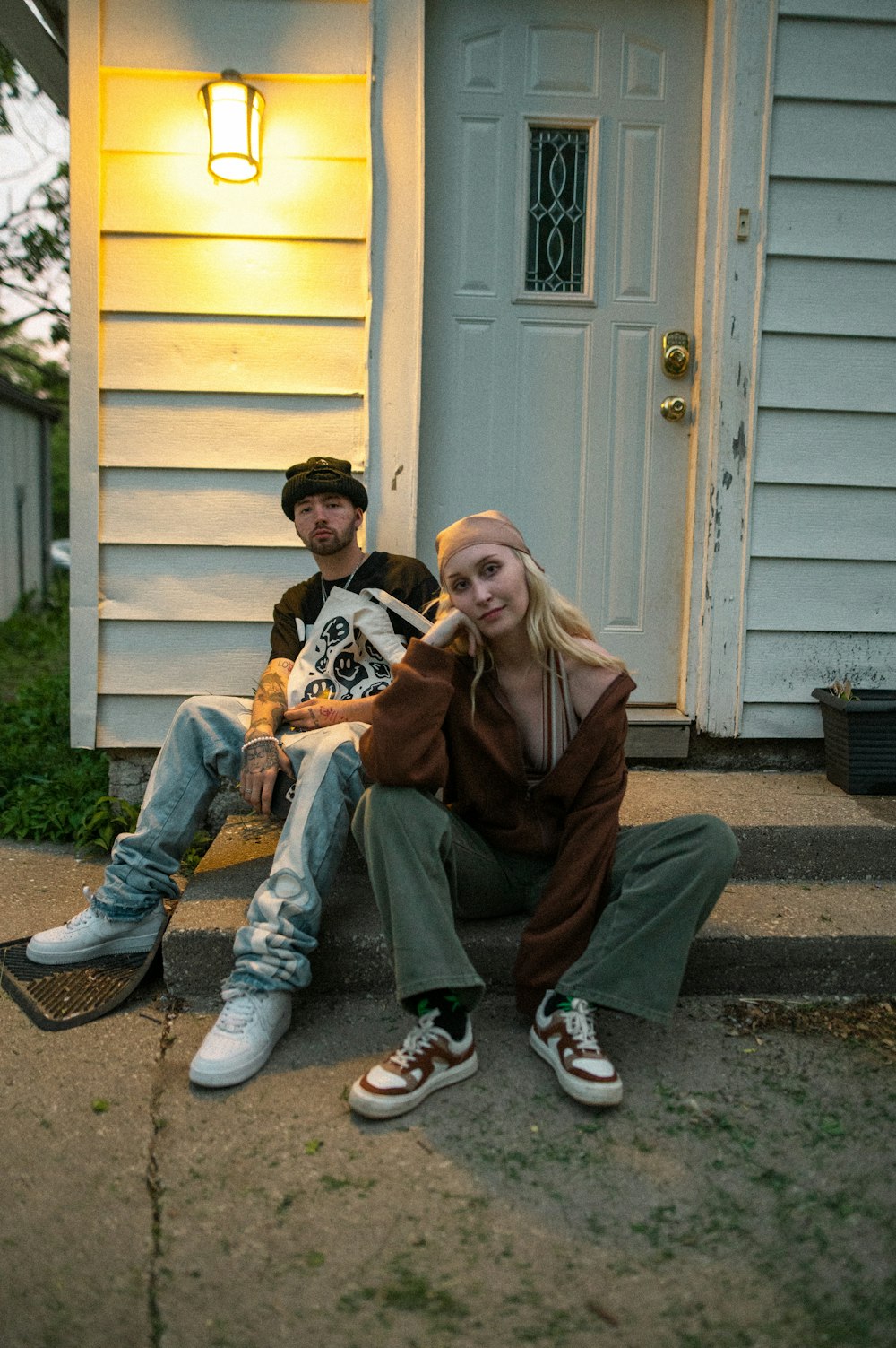 a man and a woman sitting on the steps of a house