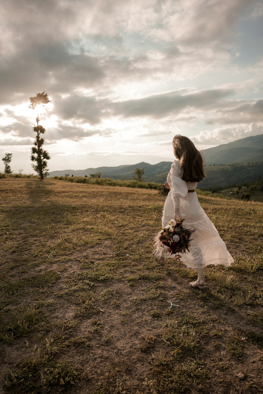 a woman in a white dress holding a bouquet of flowers