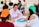 A group of diverse students engaged in an English conversation class around a table.