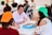 A group of diverse students engaged in an English conversation class around a table.