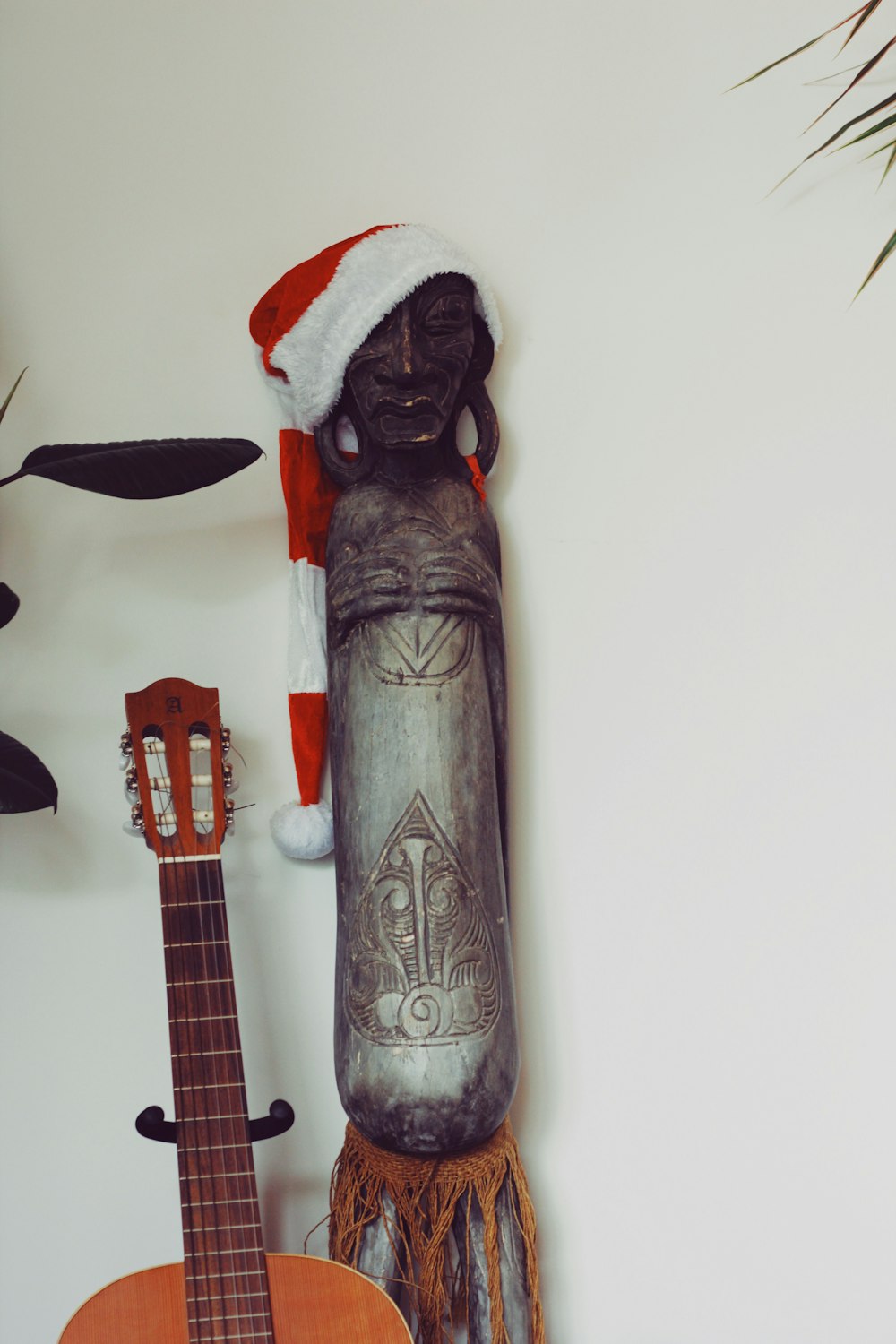 a guitar and a statue of a person wearing a santa hat