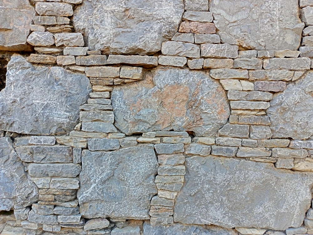 un muro de piedra con un reloj en el costado