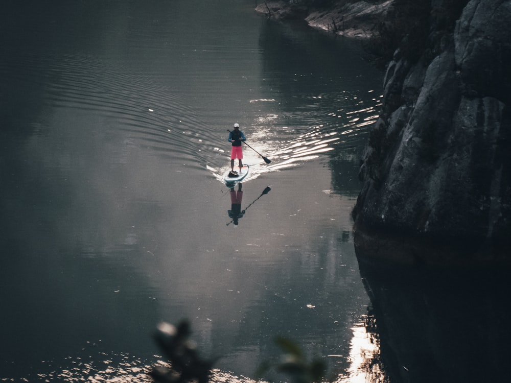 a person riding a paddle board on a body of water