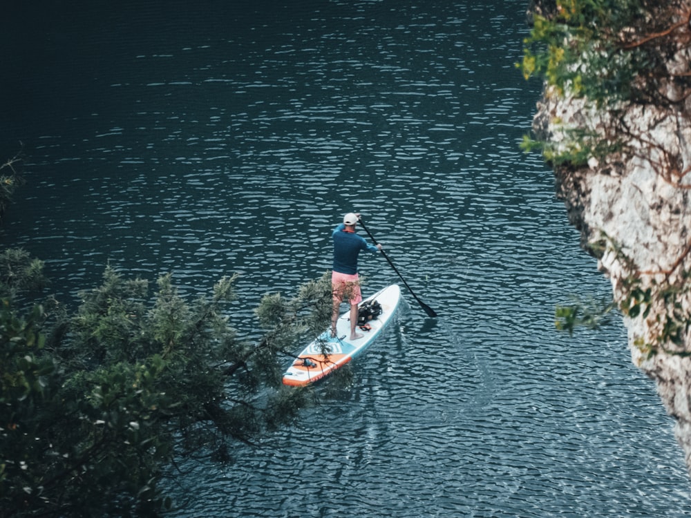 a man riding a paddle board on top of a lake