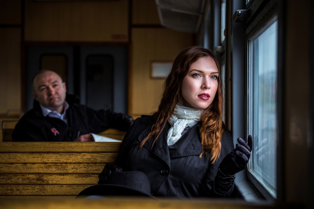 a man and a woman looking out of a train window