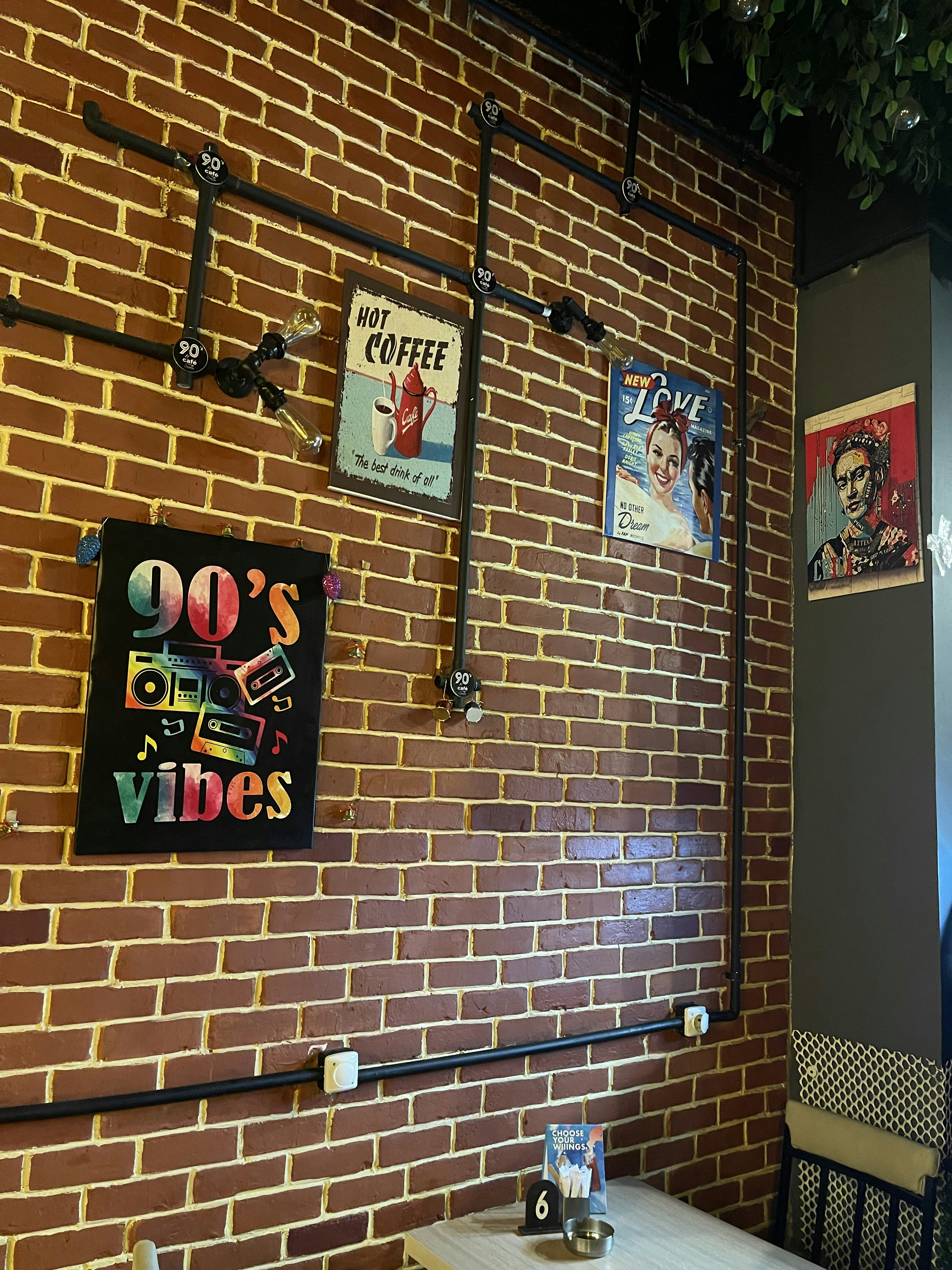a brick wall in a restaurant with posters on it
