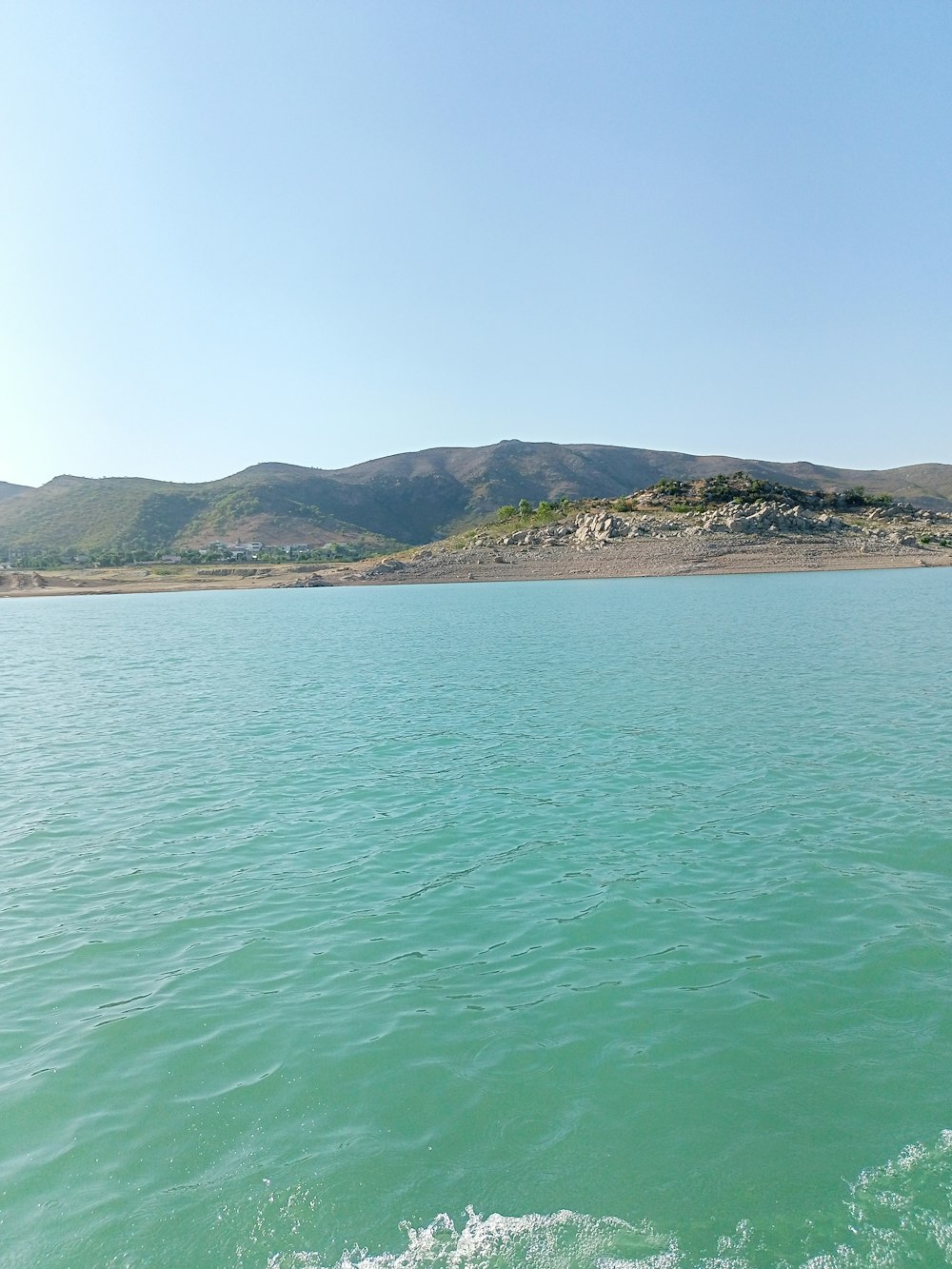 a body of water with mountains in the background