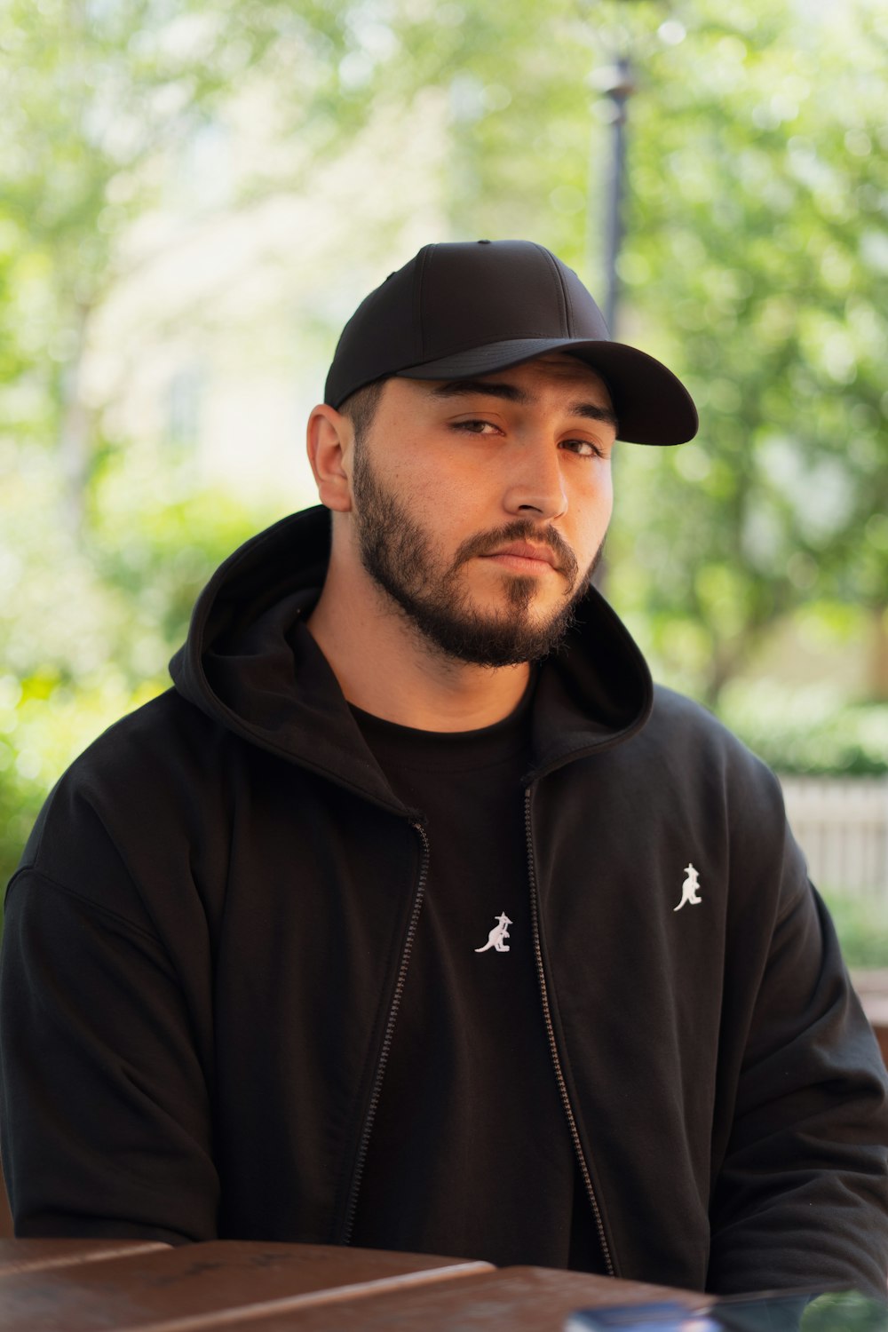 a man sitting at a table wearing a black hat