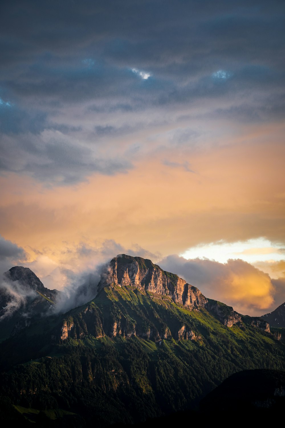 a mountain covered in a cloud covered sky