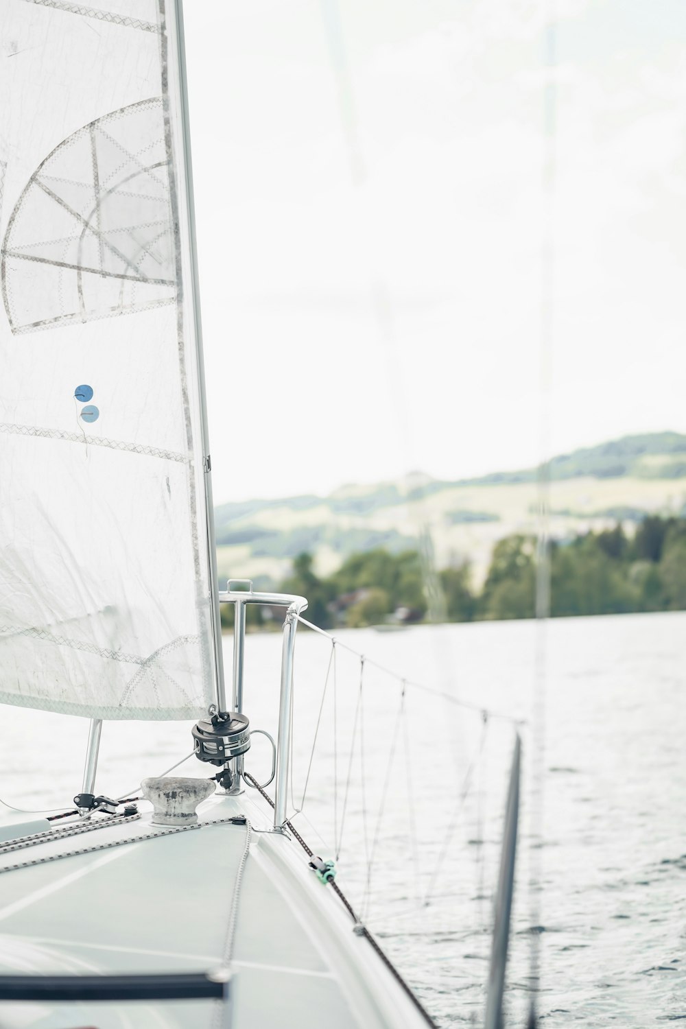 a sailboat with a white sail on a body of water