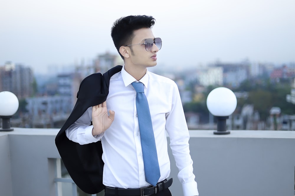 a man in a suit and tie standing on a roof