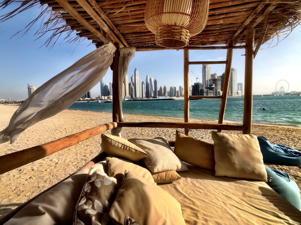 a bed on a beach with a view of the city