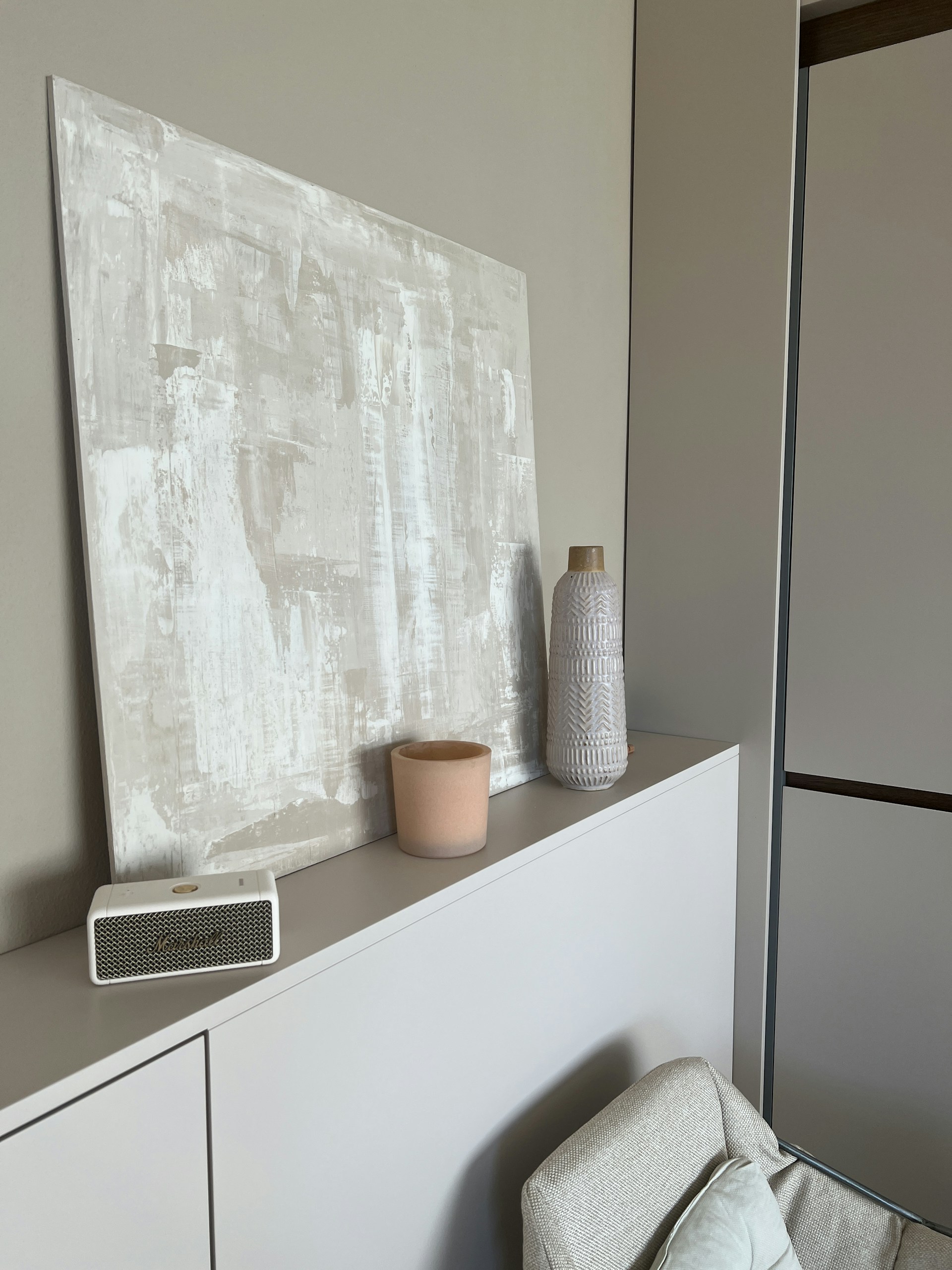 a painting on a wall above a white cabinet