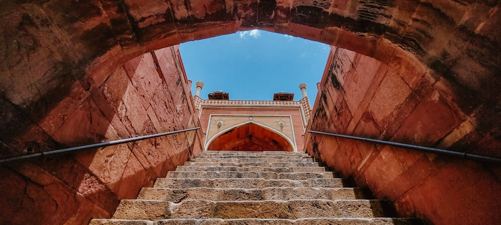 a staircase leading up to a building with a blue sky in the background