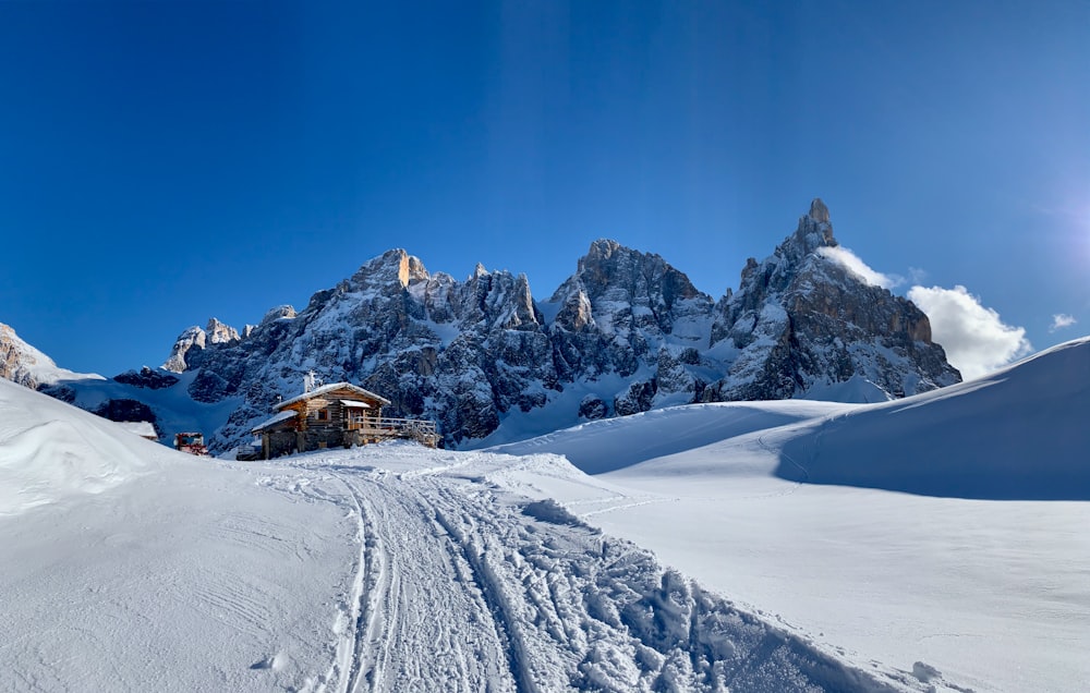 a snow covered mountain with a house on top of it