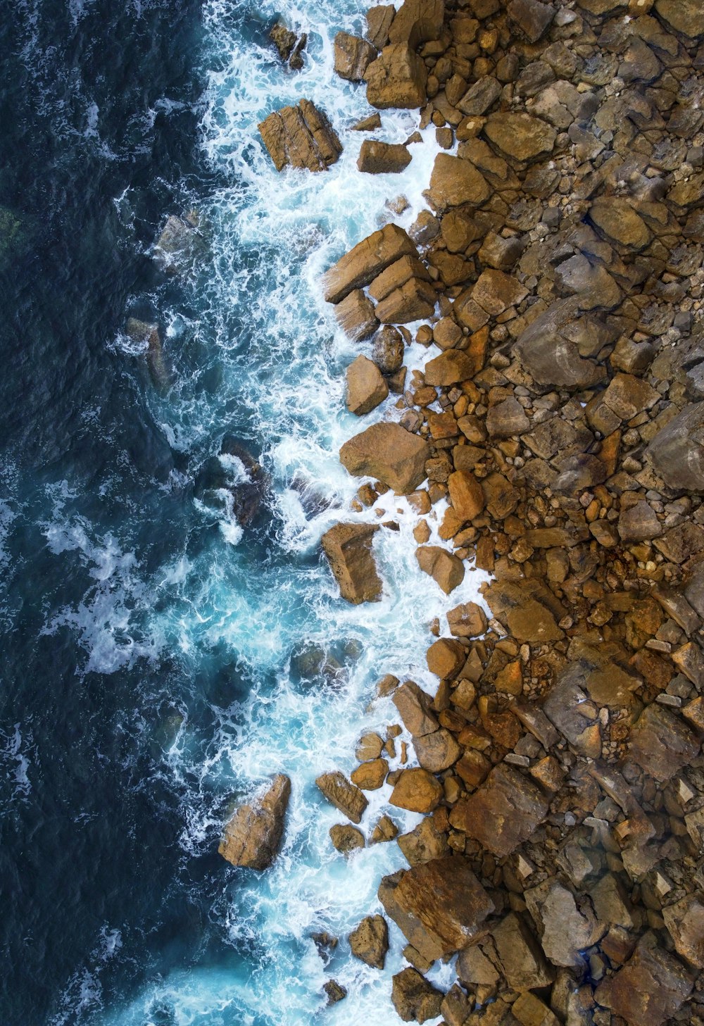 a bird's eye view of the ocean and rocks