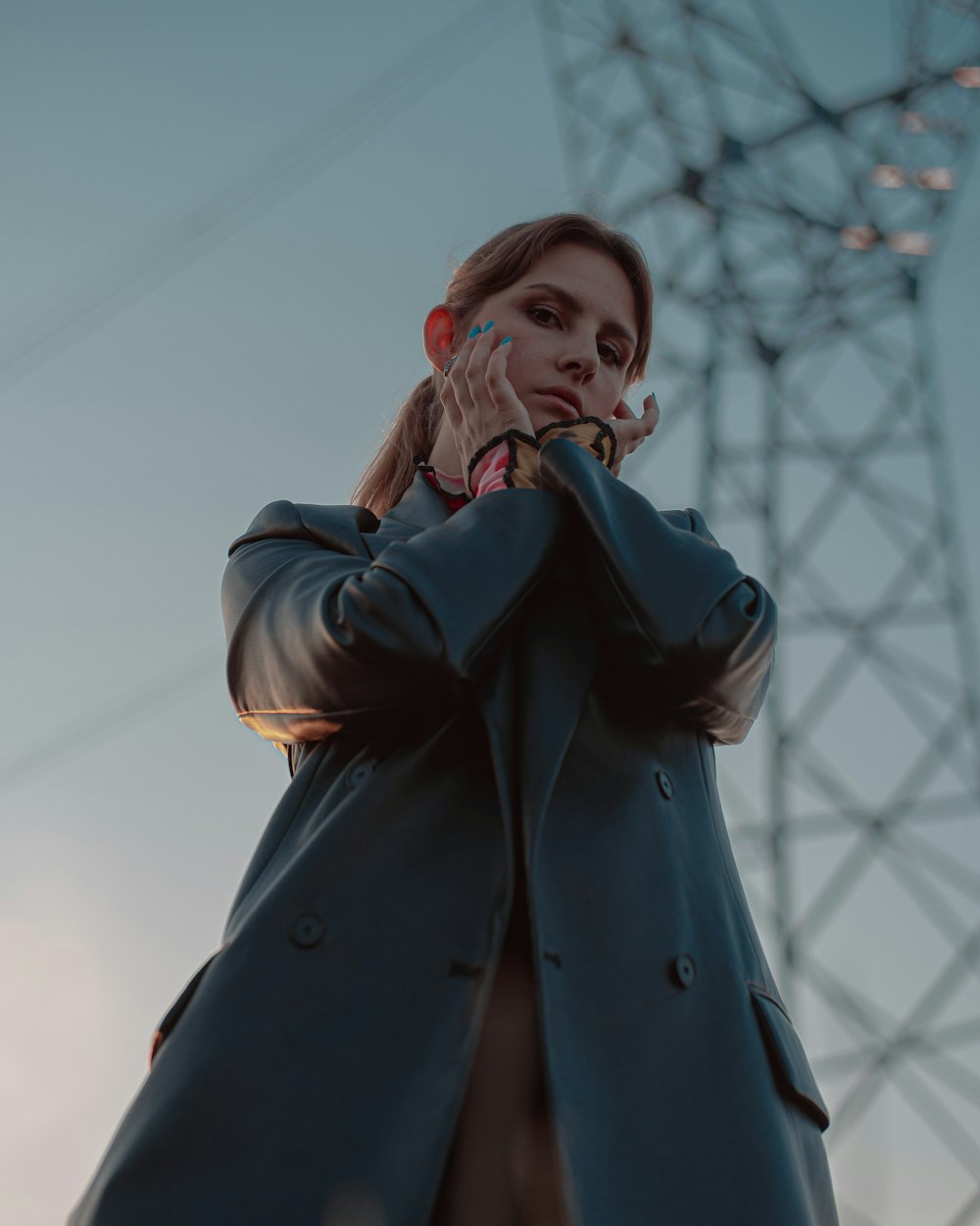 a woman standing in front of a power line talking on a cell phone