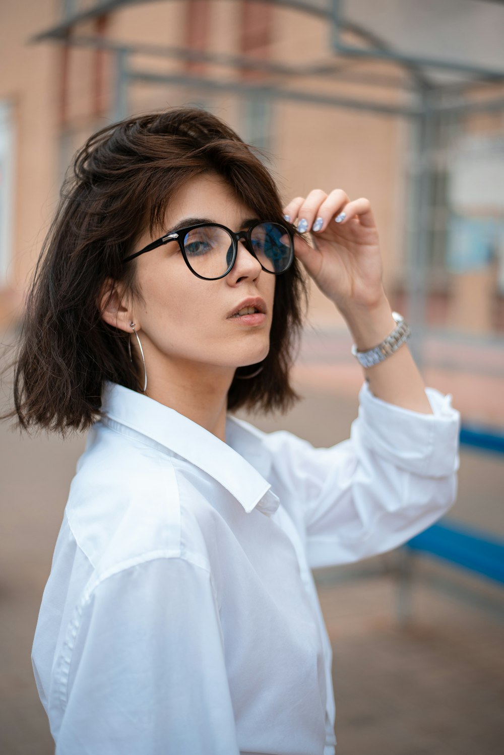 a woman wearing glasses and a white shirt