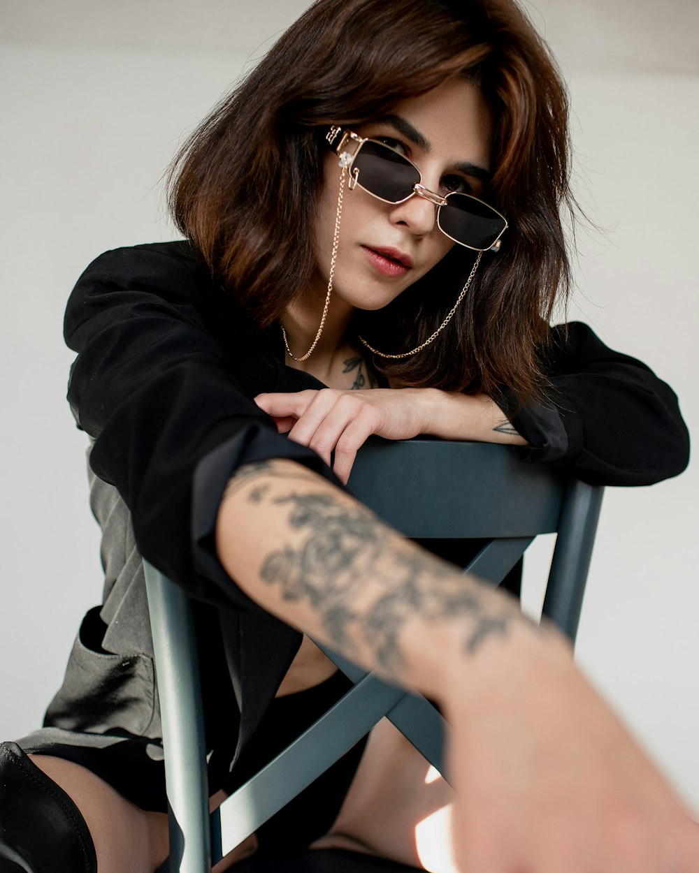 a woman sitting in a chair with a tattoo on her arm