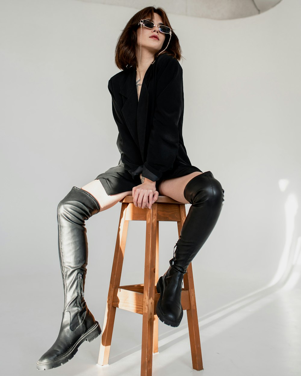 a woman sitting on top of a wooden stool