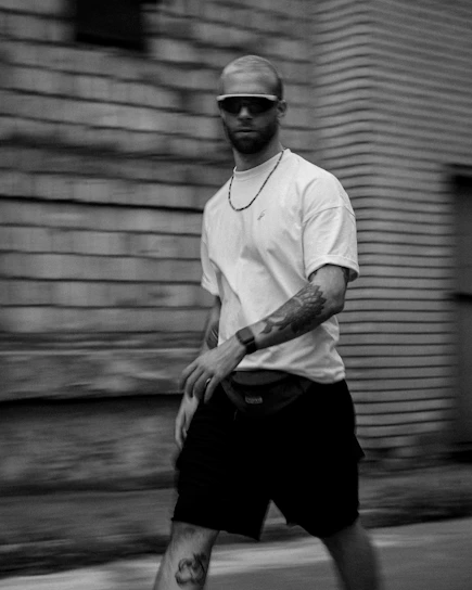a man walking down a street with a skateboard