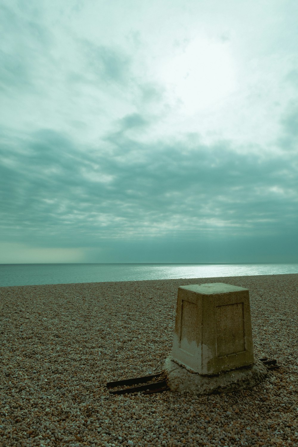 a concrete box sitting on top of a sandy beach