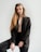 a woman in a black suit posing for a picture