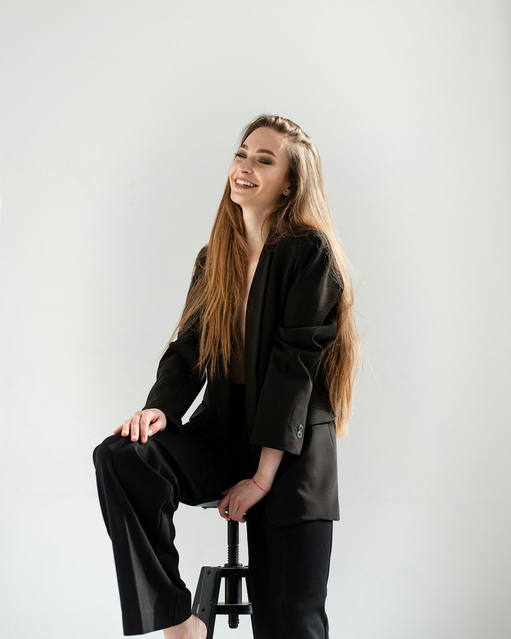 a woman sitting on a stool and smiling