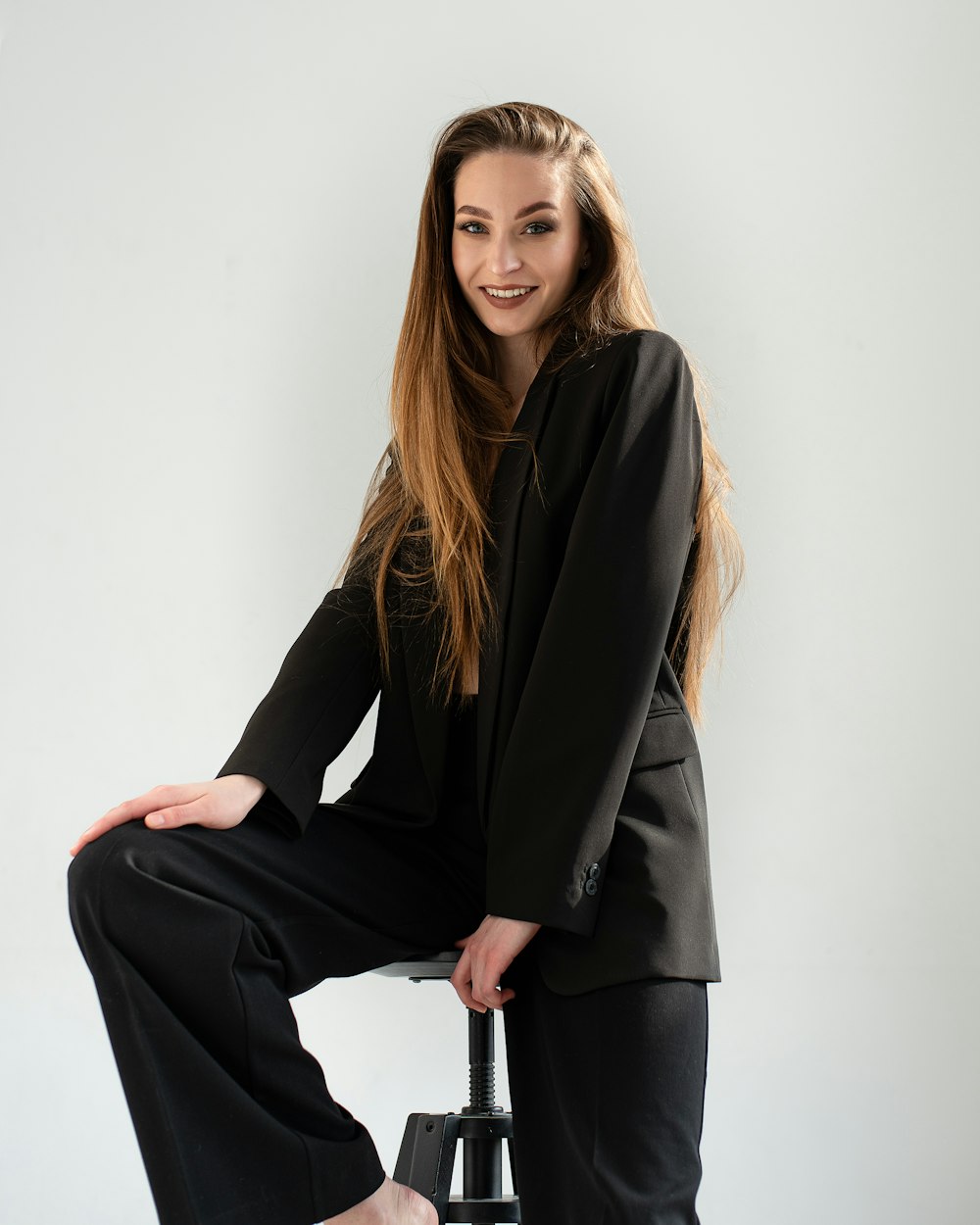 a woman sitting on a stool posing for a picture