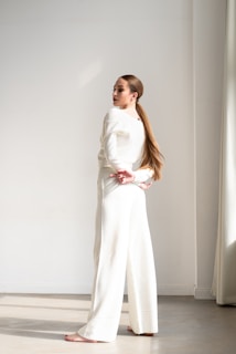 a woman standing in a room wearing a white outfit