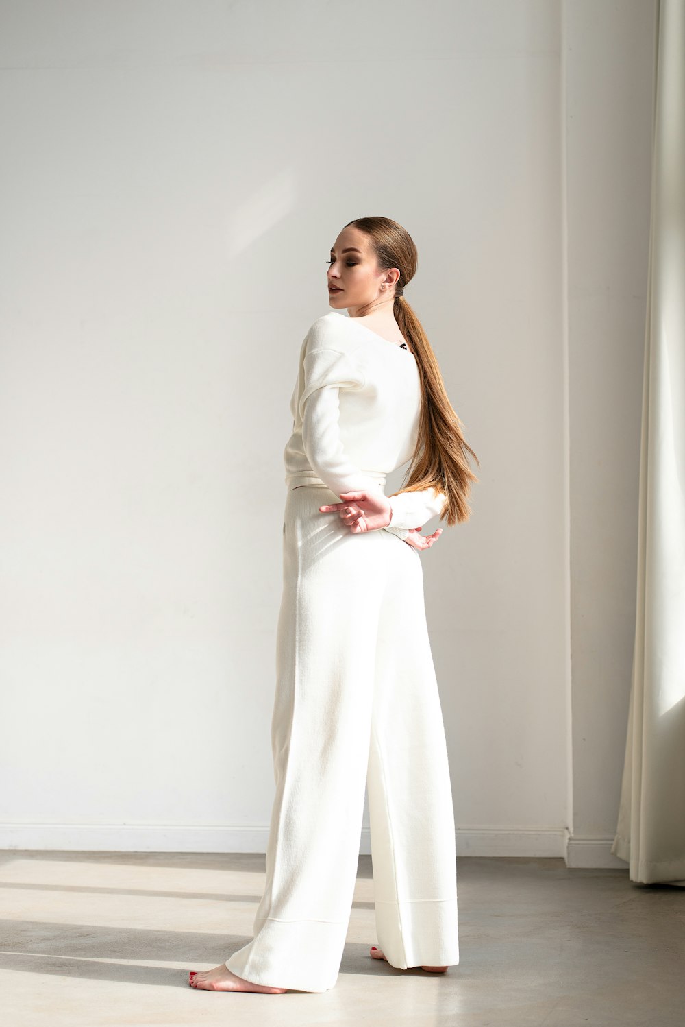 a woman standing in a room wearing a white outfit