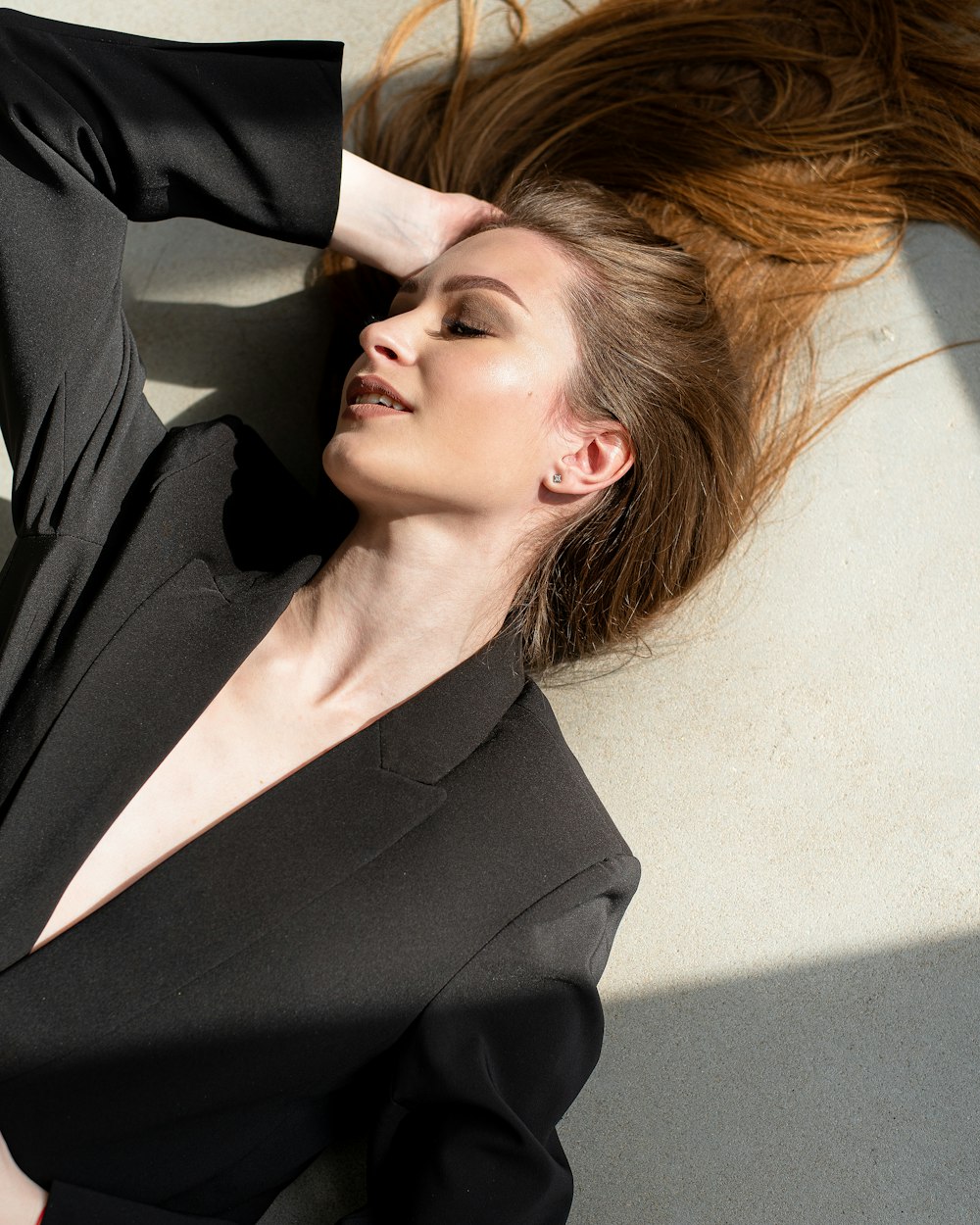 a woman laying on the ground with her hair blowing in the wind