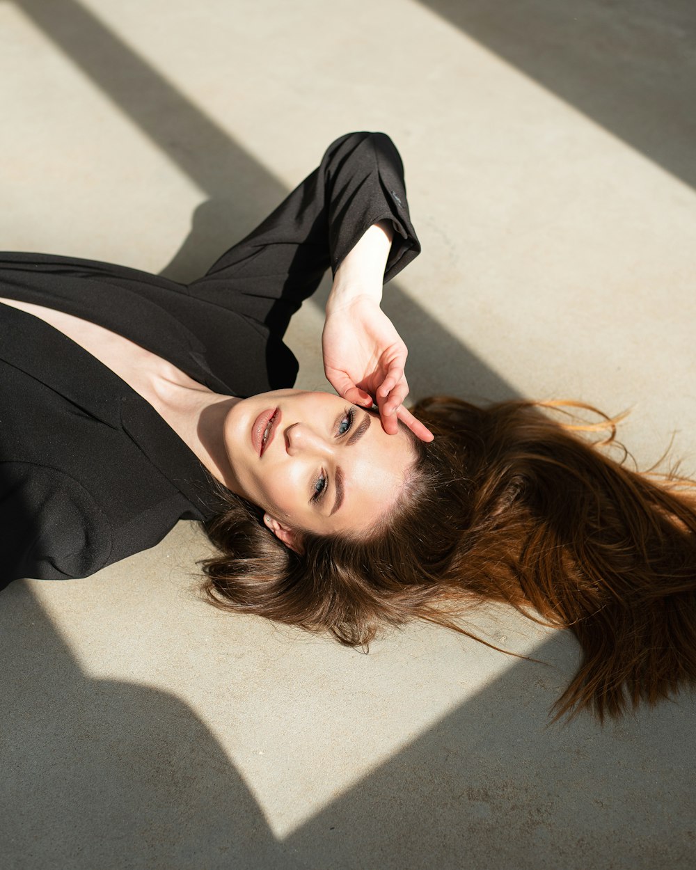 a woman in a black dress laying on the ground