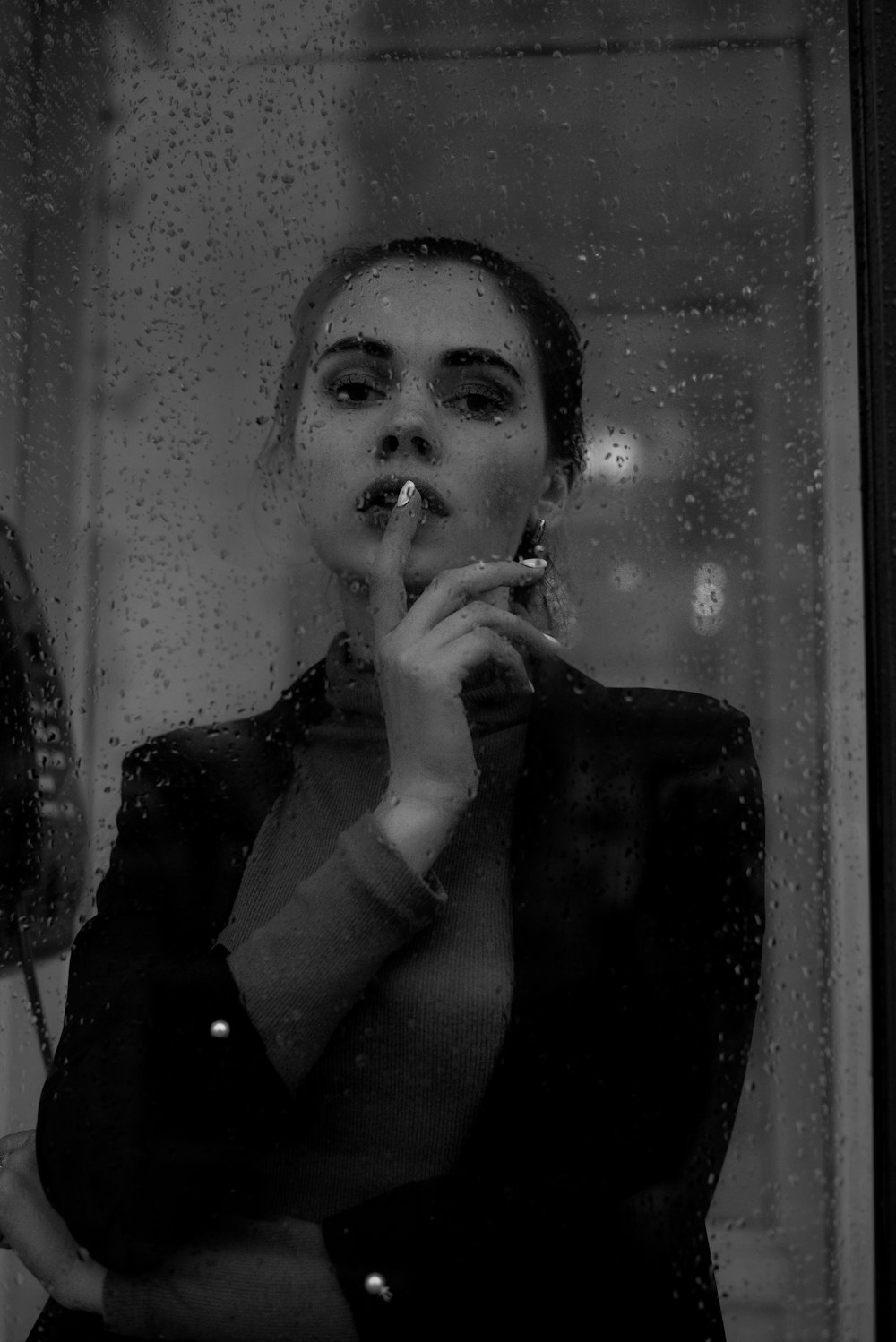 a woman smoking a cigarette in front of a window