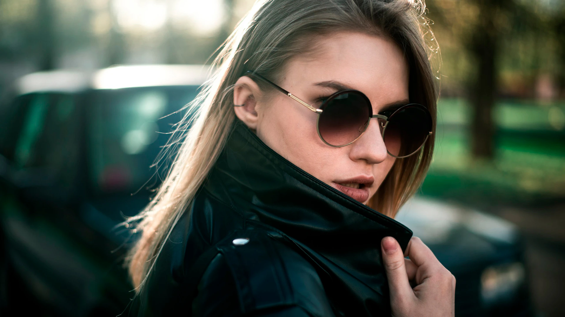 a woman wearing sunglasses and a black jacket