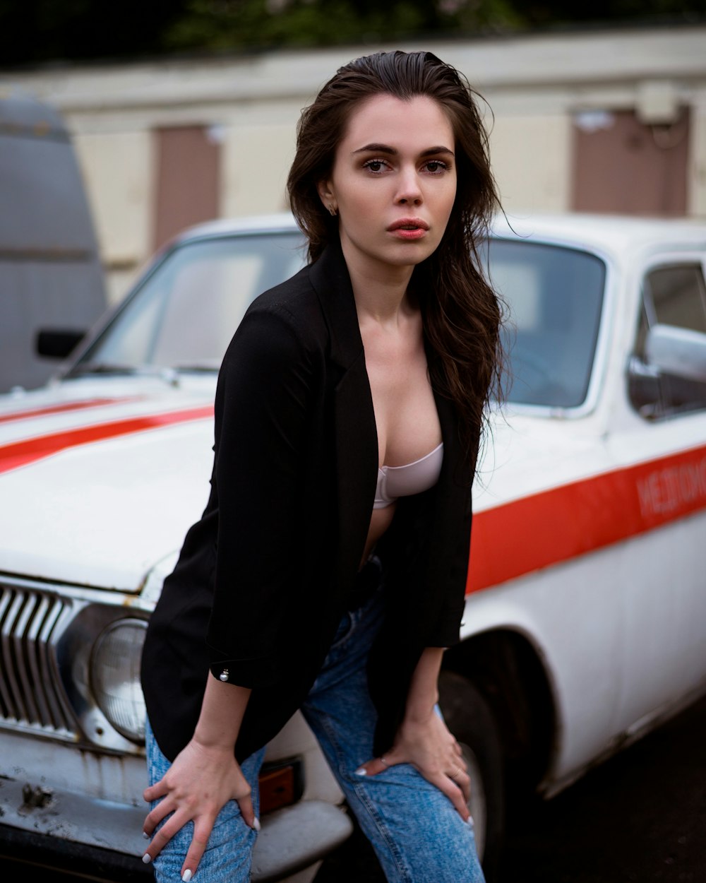 a woman sitting on the hood of a car