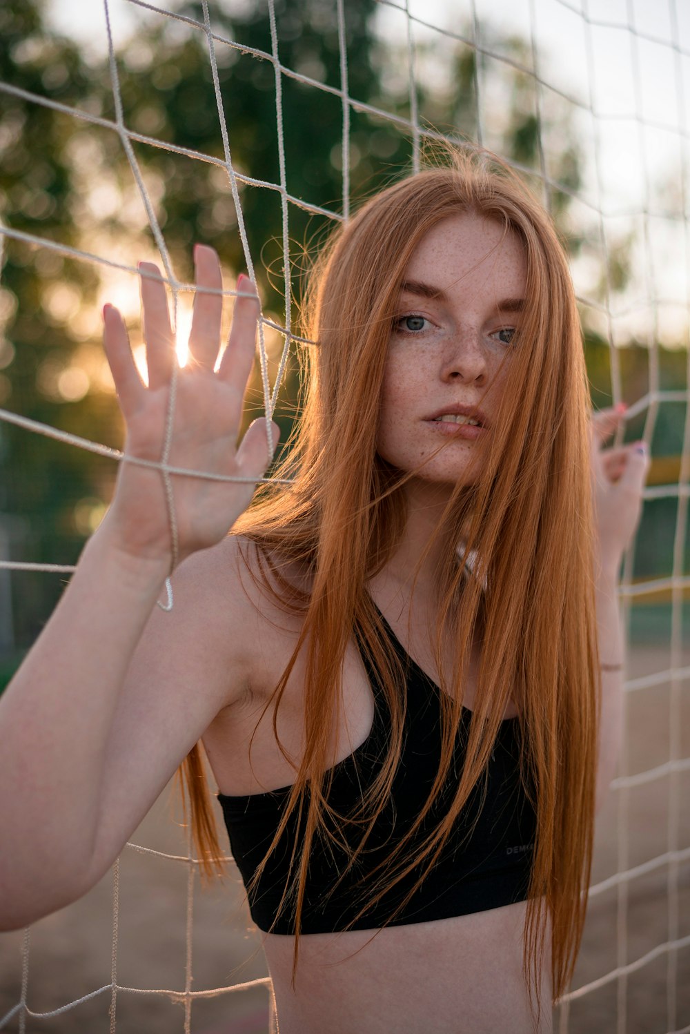 a woman with freckled hair standing in front of a net
