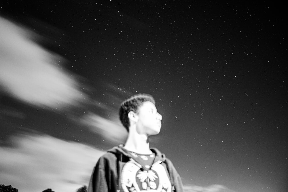 a young man is looking up at the stars in the sky