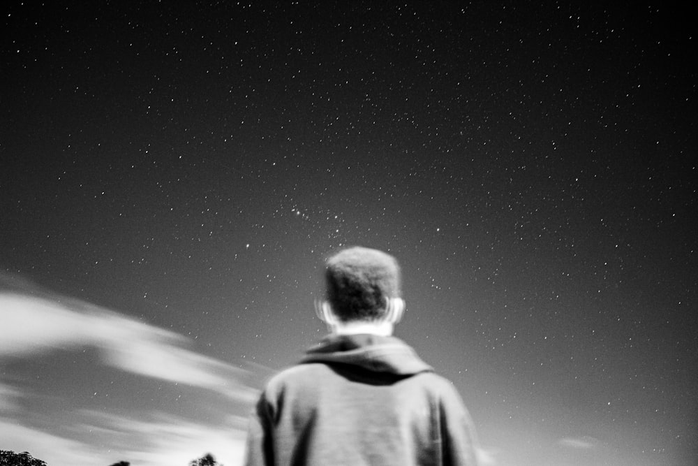 a man looking up at the stars in the sky