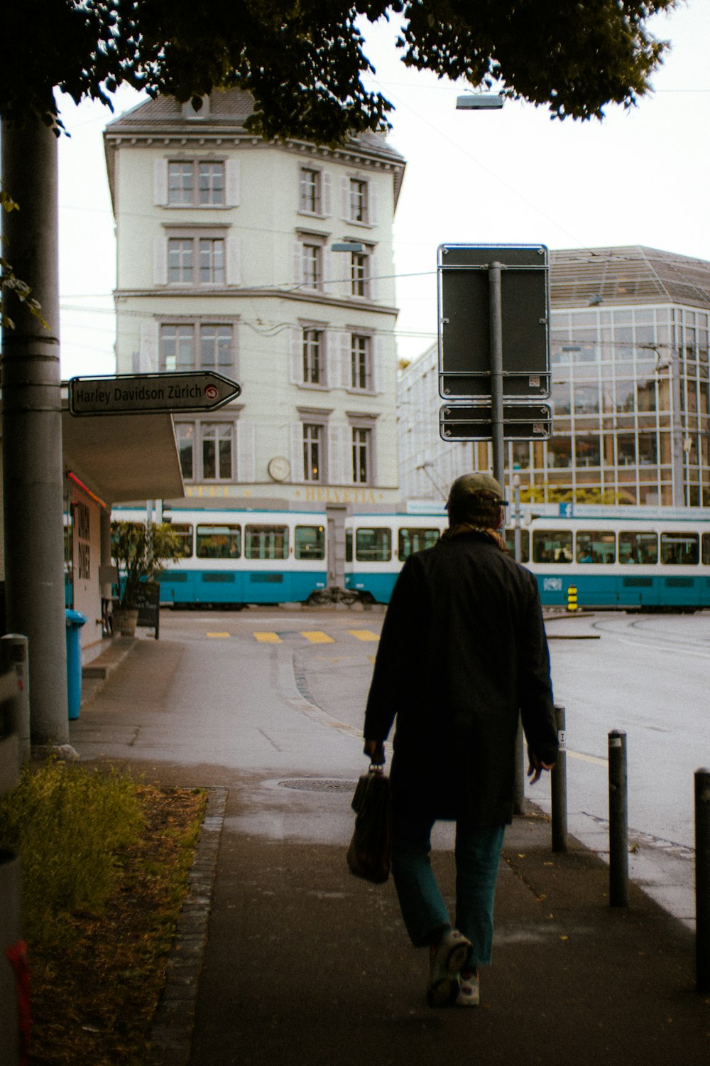 a man walking down a sidewalk next to a building