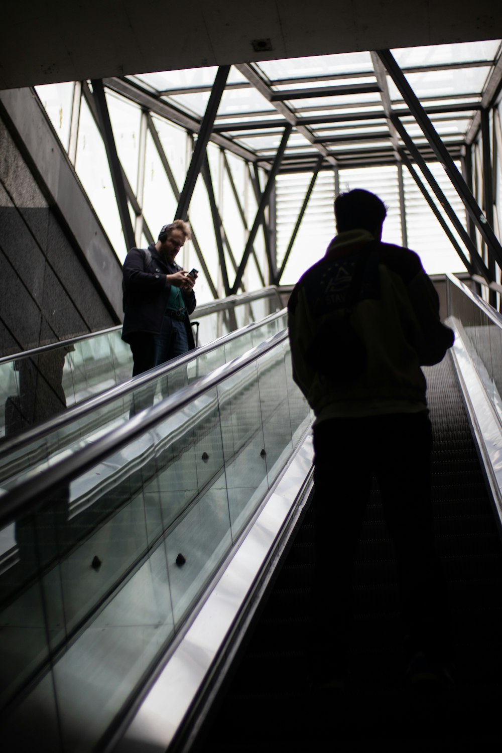 a couple of people riding down an escalator