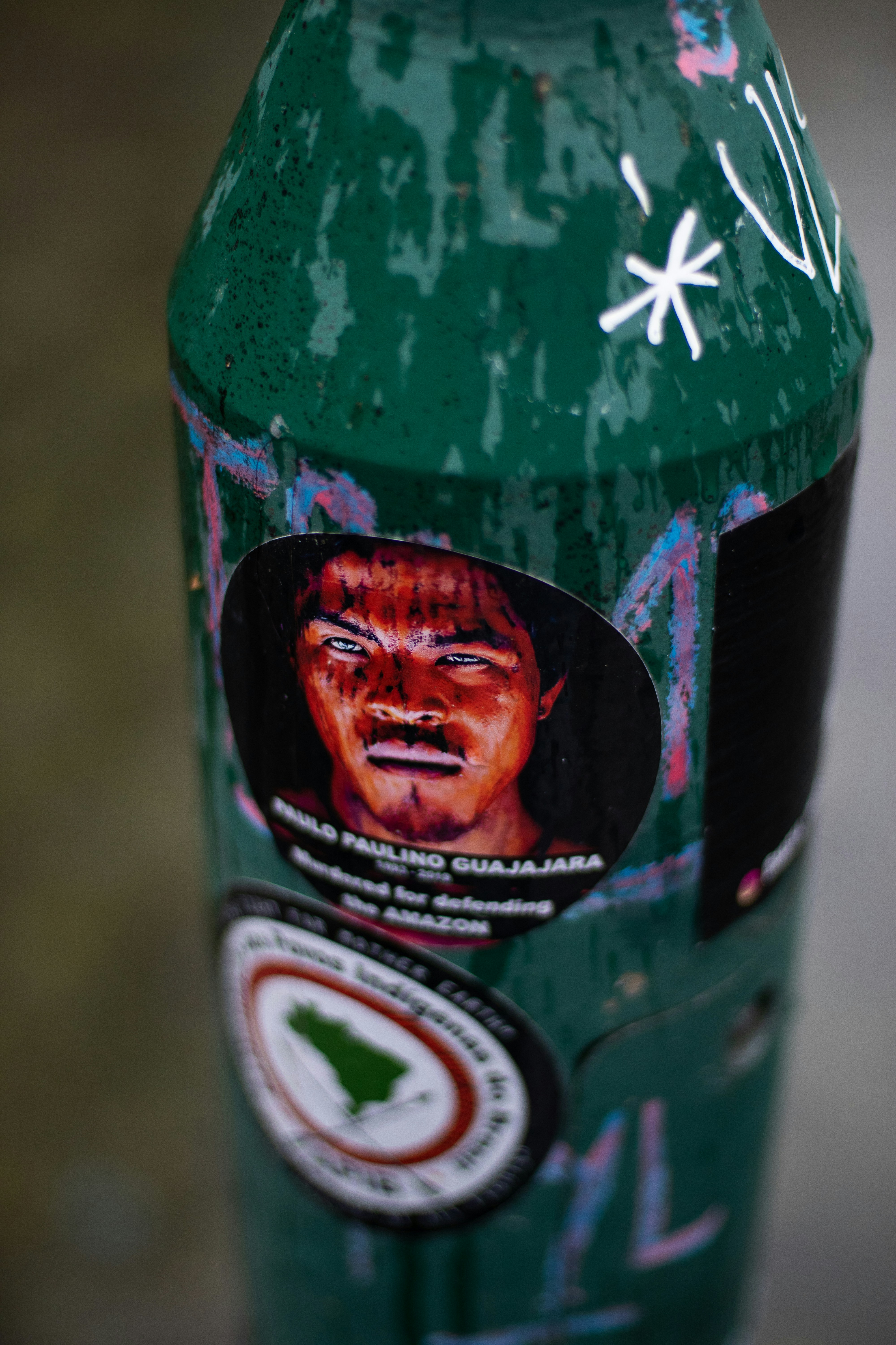 Un primer plano de una boca de incendios verde con pegatinas