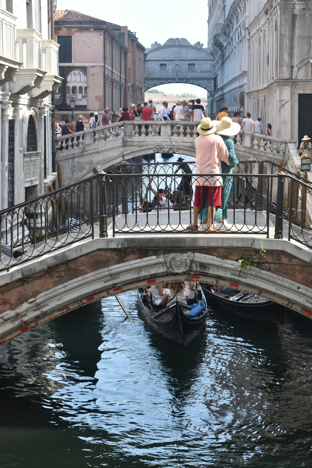 a couple of people standing on a bridge over a river