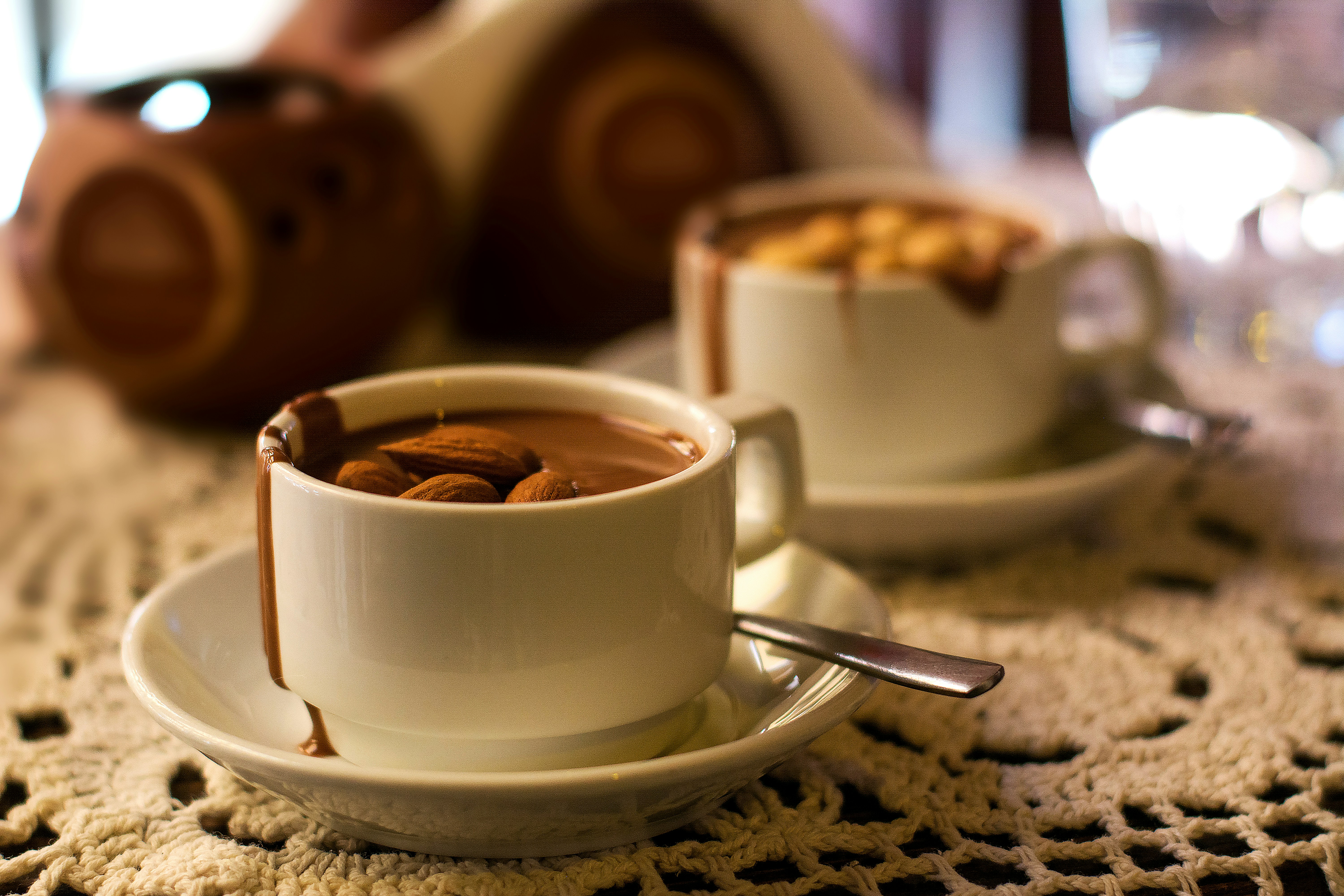 two cups of hot chocolate with nuts in them