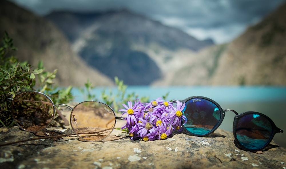 a pair of sunglasses sitting on top of a rock