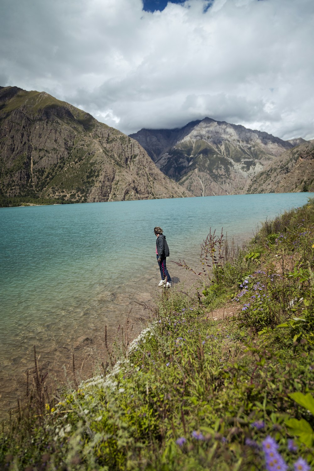 a person standing on the shore of a lake