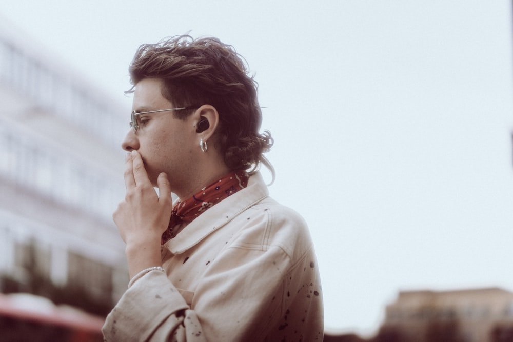 a man wearing glasses and a white shirt is talking on a cell phone