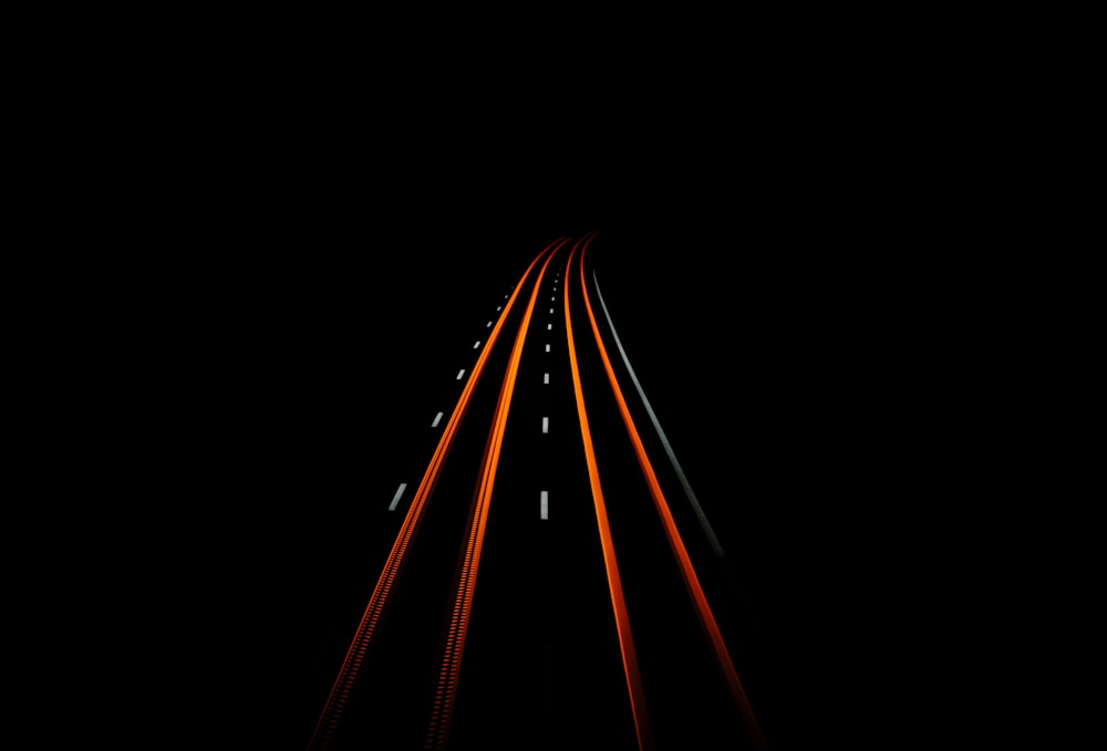 a long exposure photo of a highway in the dark