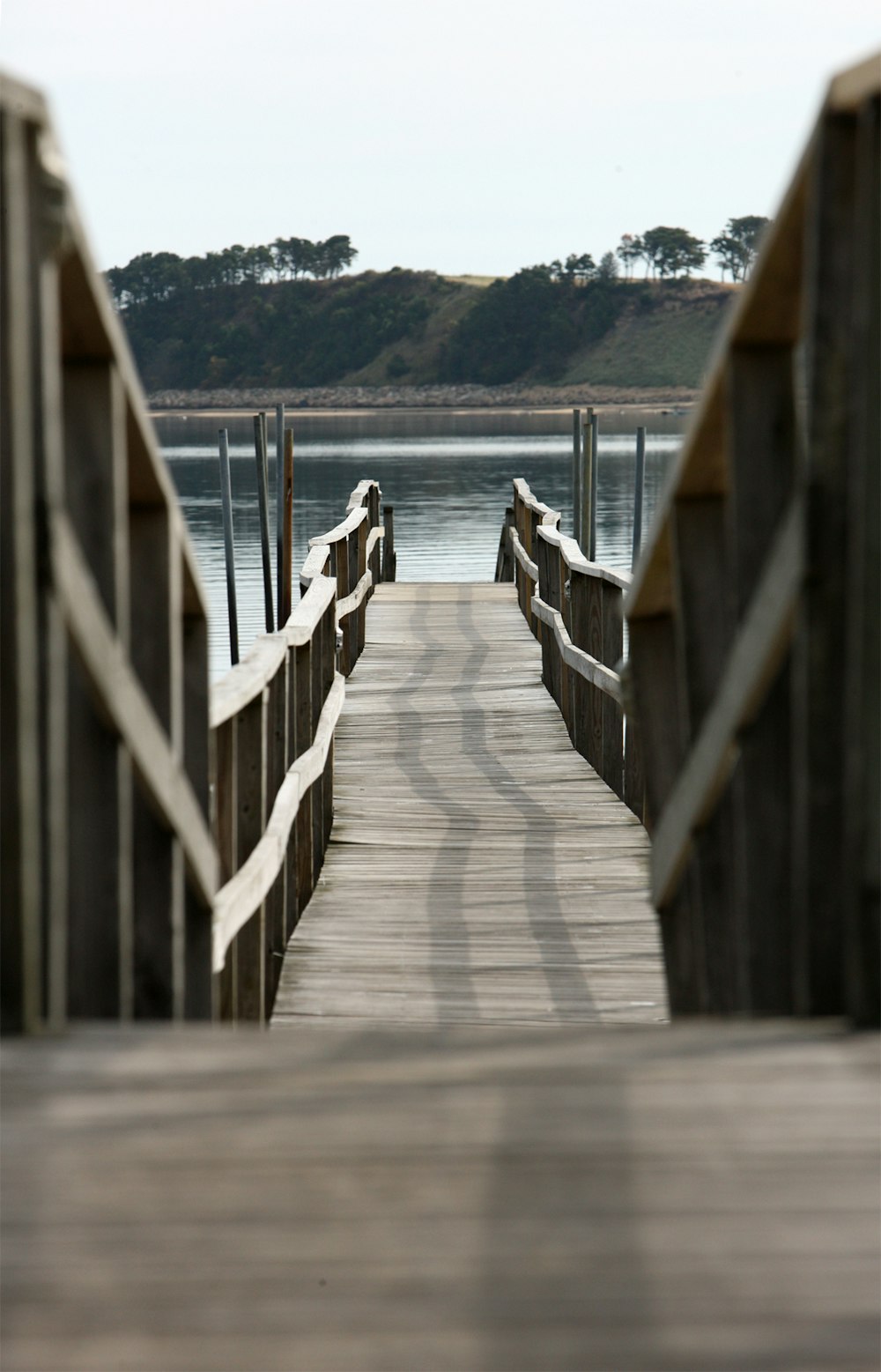 a wooden pier with a few poles sticking out of it