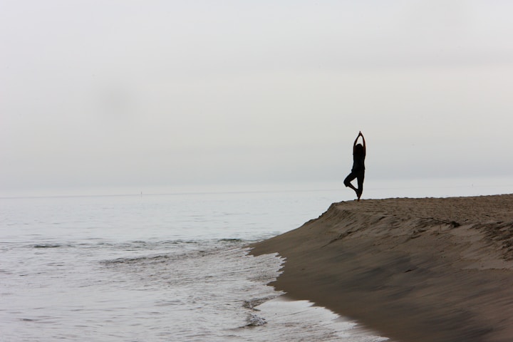 a person standing on top of a sandy beach next to the ocean